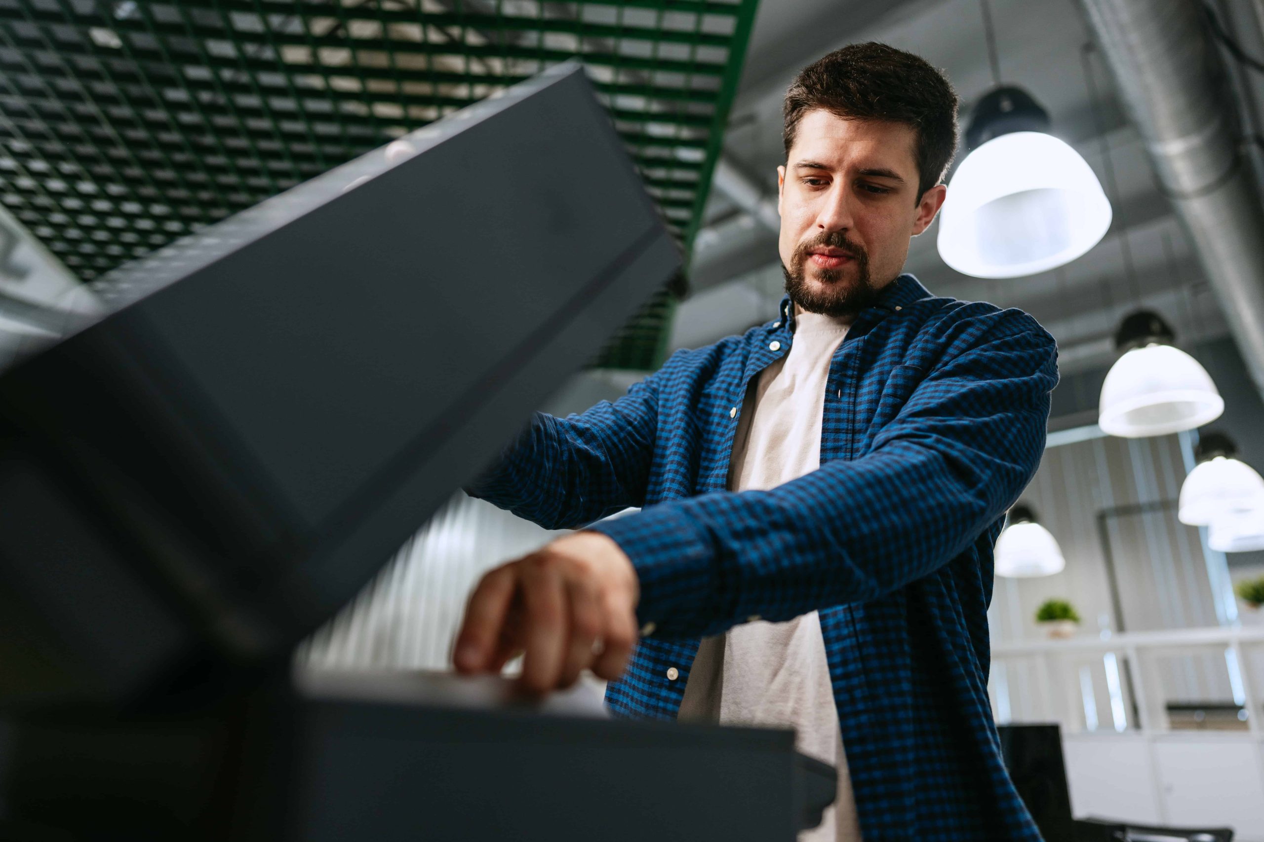 young-man-operating-modern-office-printer-while-focused-printing-documents-quiet-workspace (2) Onsite Home Shredding Services in Cincinnati